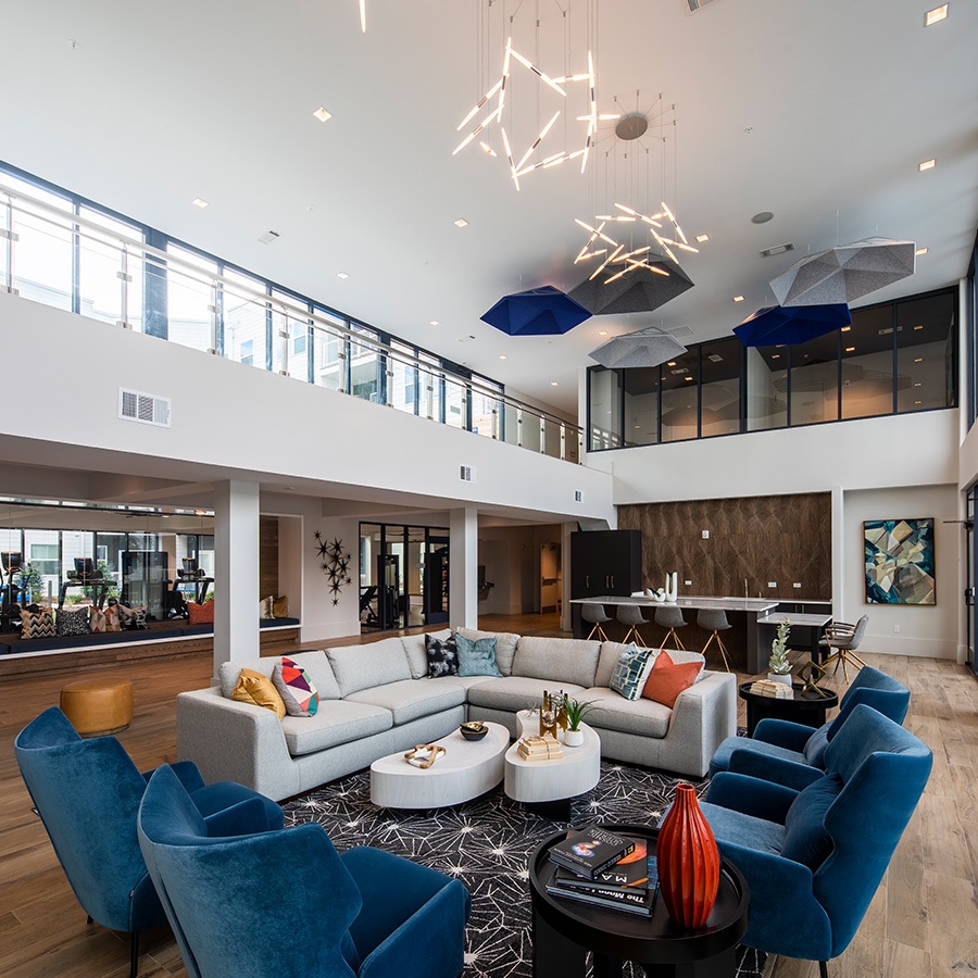 Clubhouse lounge with comfortable seating, high ceilings, and large windows.