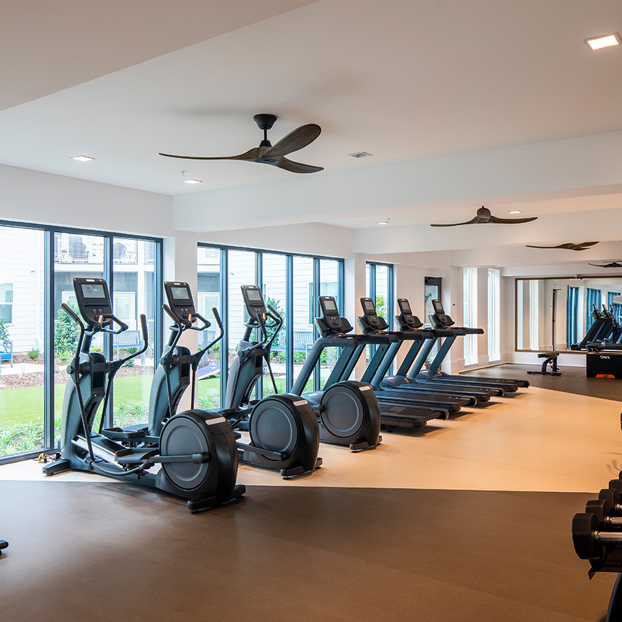 Fitness center with cardio machines and floor to ceiling windows.